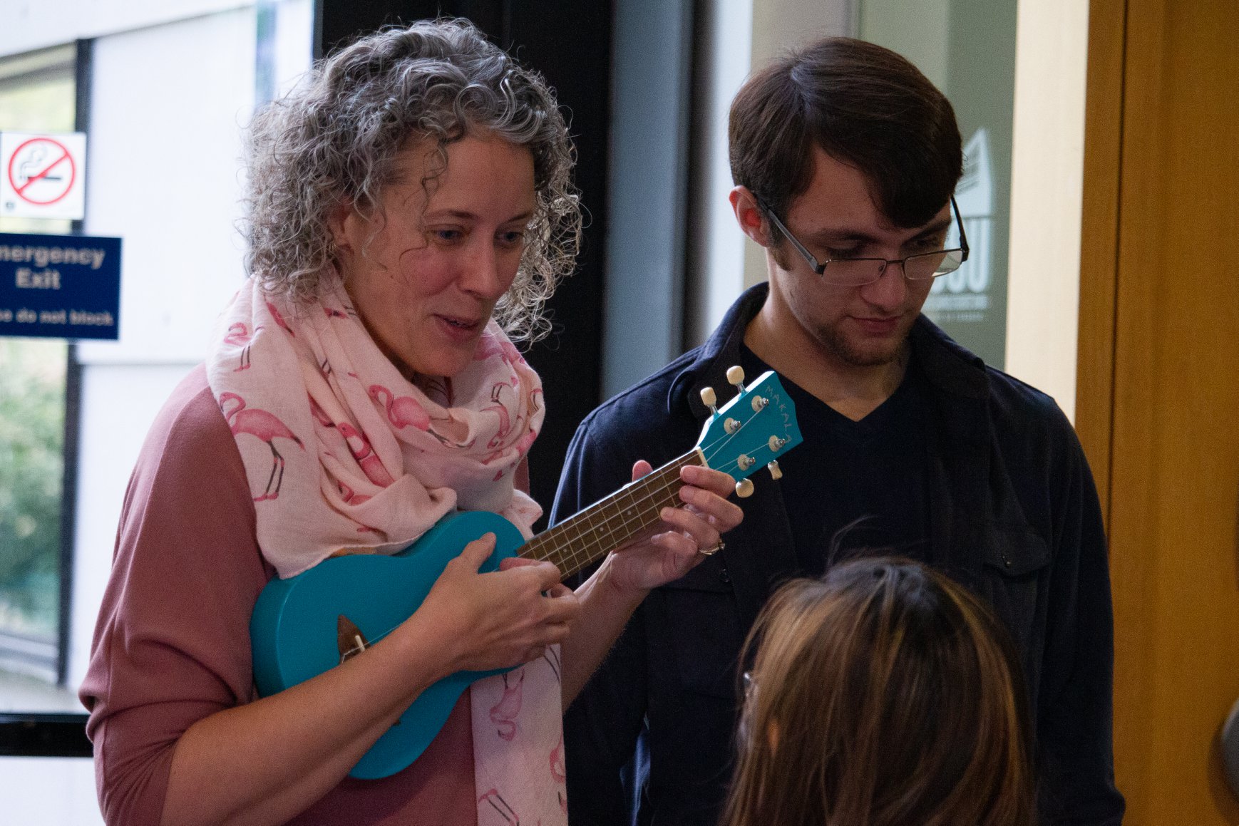 Two facilitators with a ukulele singing along with a participant