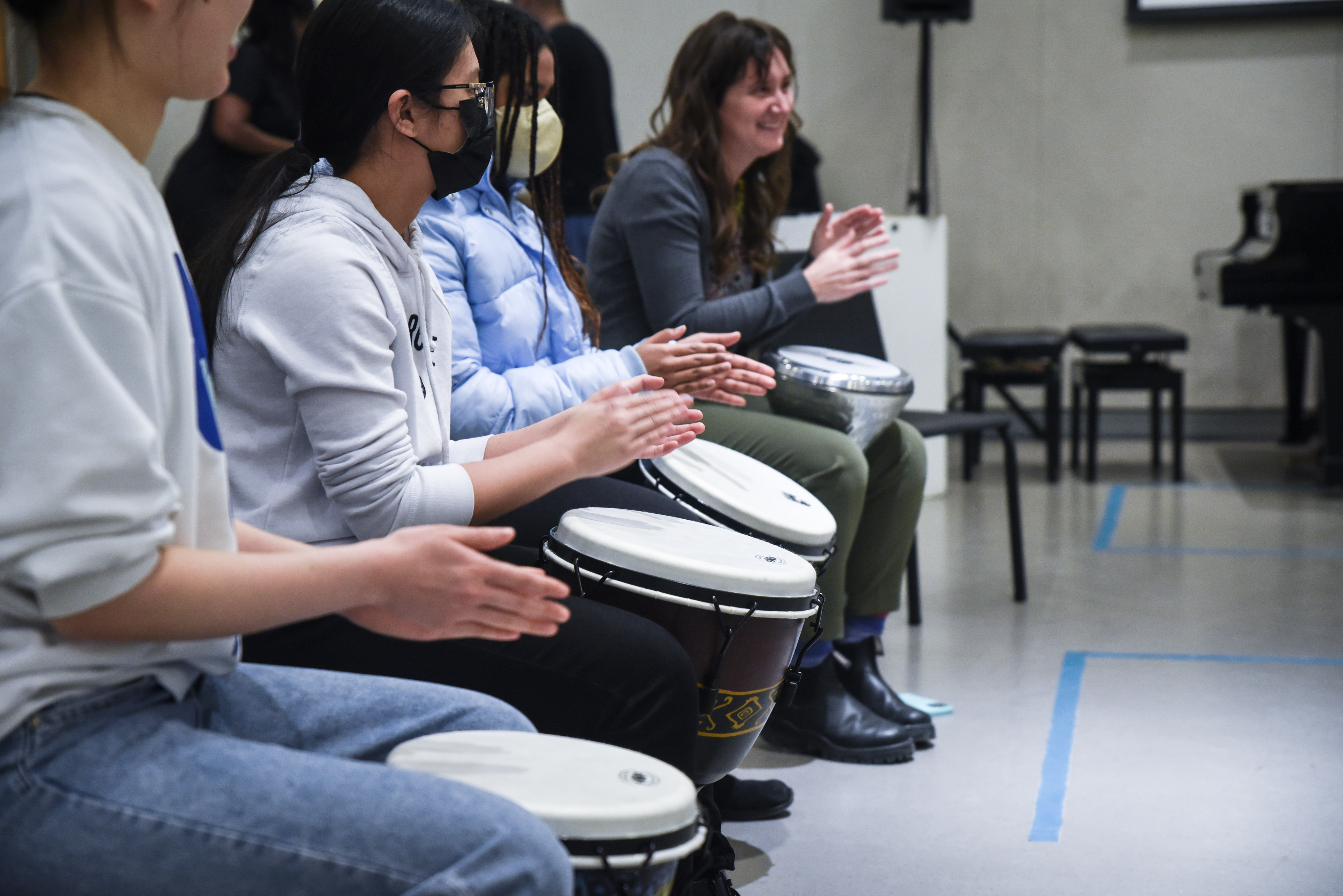 Participants hand drumming in a line